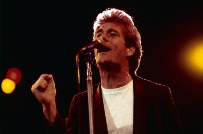 A man singing into a microphone on Broadway.