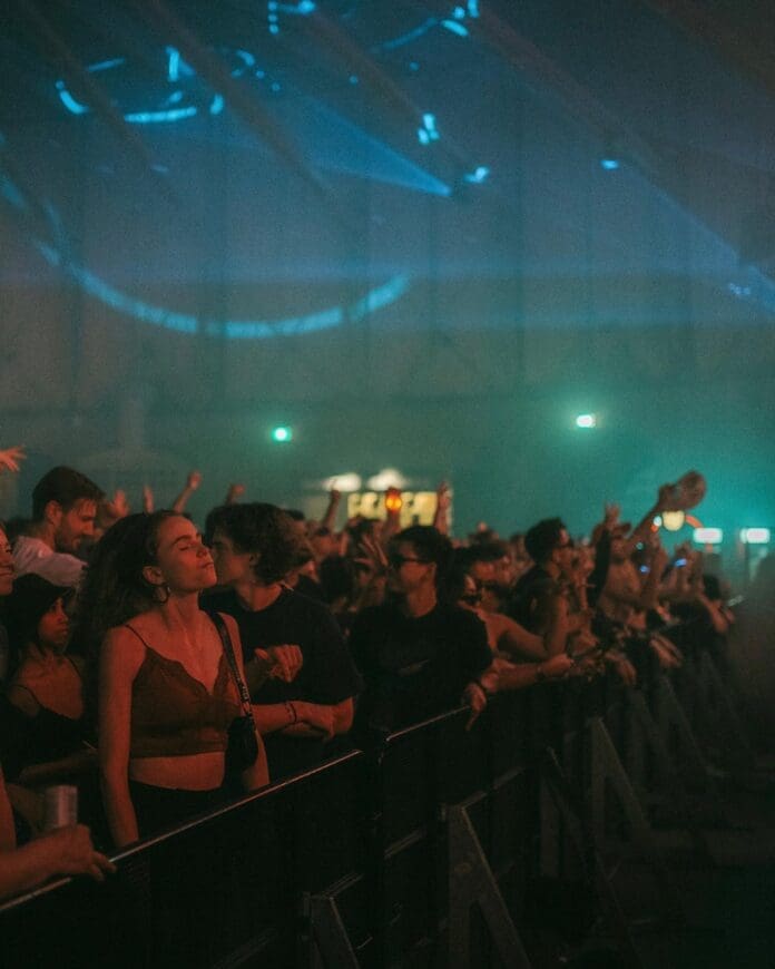 A group of individuals enjoying ADE Live Sets at a music festival.