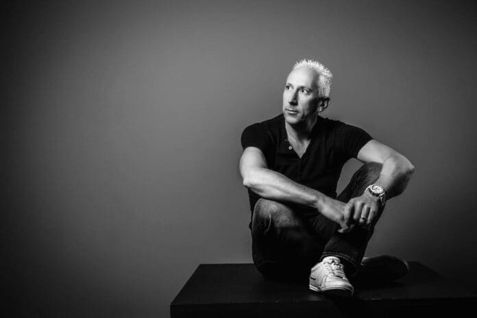 A black and white photo of Johan Gielen sitting on a box.