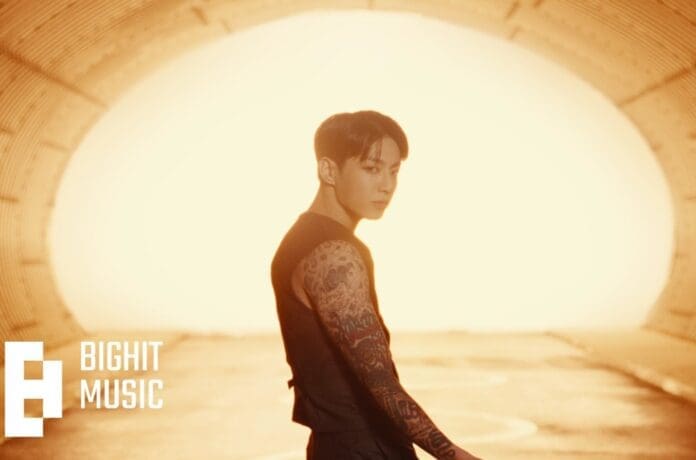 Jung Kook, a man with tattoos, shares his music video in a tunnel.