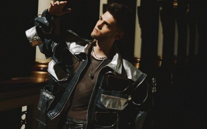 Martin Trevy, a man from Colombia, effortlessly leans against a wall, his leather jacket adding to his rhythmic heart.