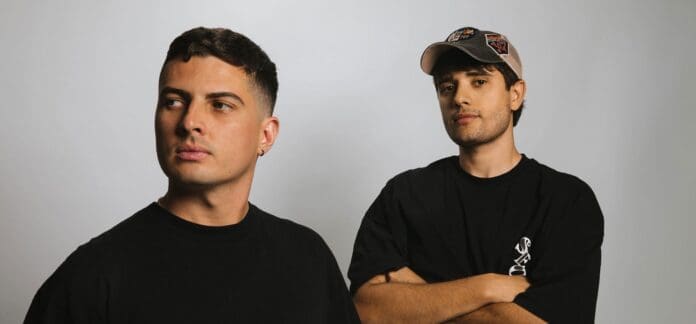 Two men in black t-shirts standing next to each other.