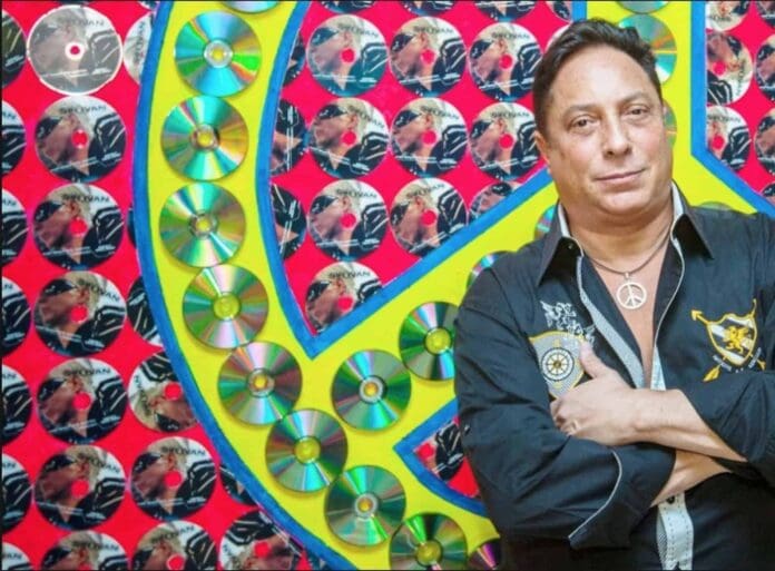 A man with his arms crossed in front of a peace sign, symbolizing Peace On Earth.