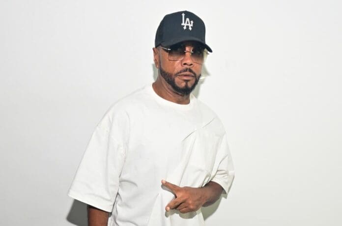 A man in a white shirt and hat, resembling Justin Timberlake, is posing for a picture.