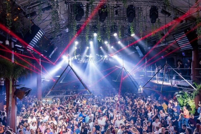 A lively crowd of people dancing to music at a nightclub on a Friday night.