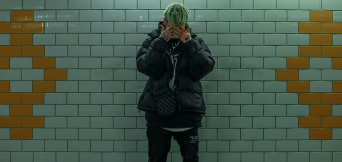 A barnacle boi is standing in a subway station holding a cactus.