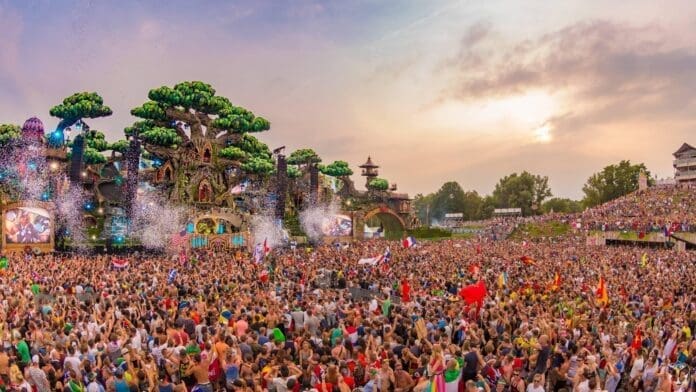 A large crowd of people celebrating at Tomorrowland 2024, a music festival.