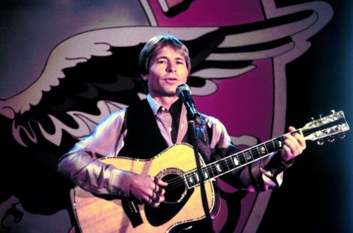 A man playing an acoustic guitar in front of a majestic eagle, reminiscent of John Denver's soulful melodies.