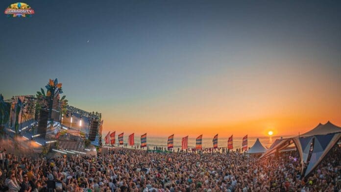 An electrifying crowd at a music festival, captivated by the luminosity of the sunset.