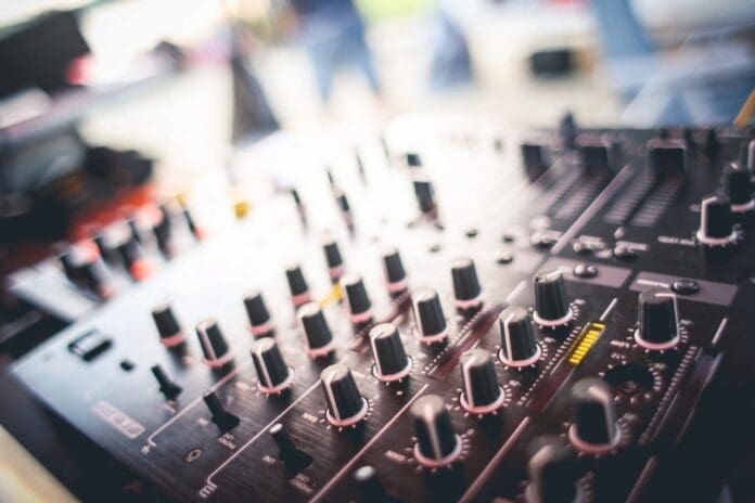 A close up of a dj mixer with blurred background, highlighting the vibrant Music Industry.