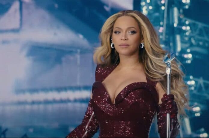 Beyonce at the L.A. Film Premiere in a red dress, holding a sword.